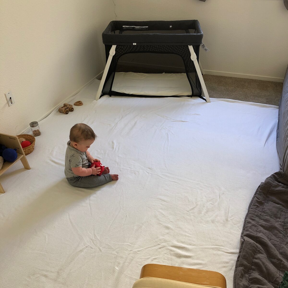 Our Montessori floor bed setup: a thin mattress on the floor with a low Guava Lotus
