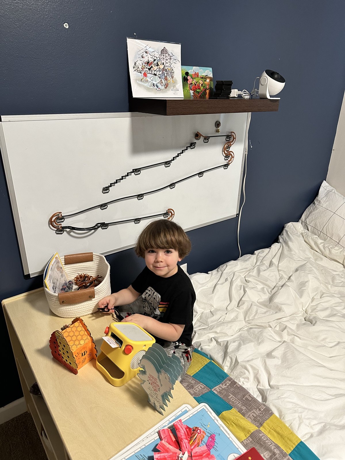 A magnetic marble run on the wall of a space themed kids room